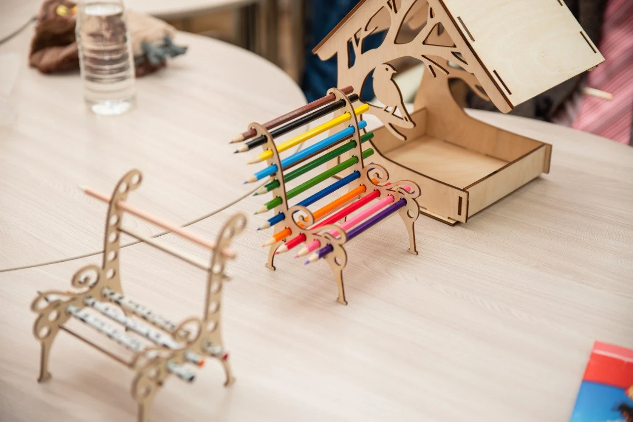 Деревянные предметы интерьера: часы с гравировкой, настольный органайзер, светильник и декоративные панели.