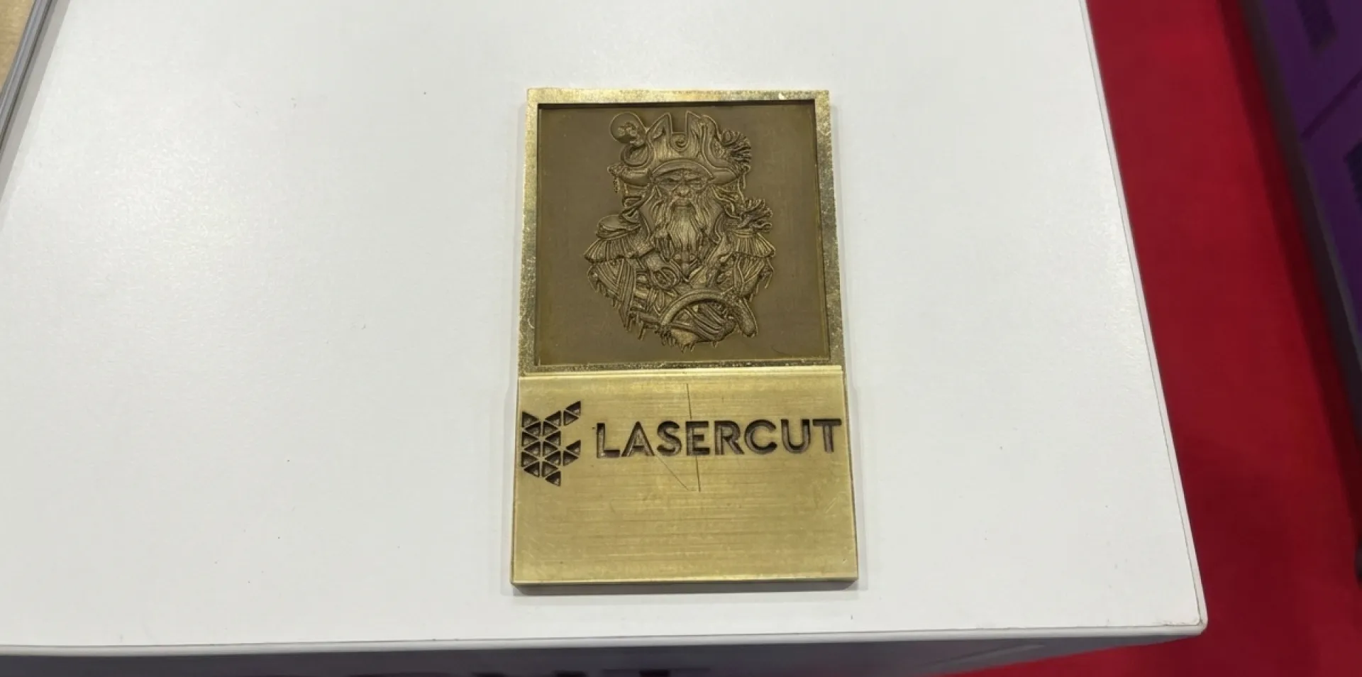 Глубокая лазерная гравировка портрета пирата и логотипа Lasercut на латунной пластине. Четкая маркировка на маркере Wattsan.