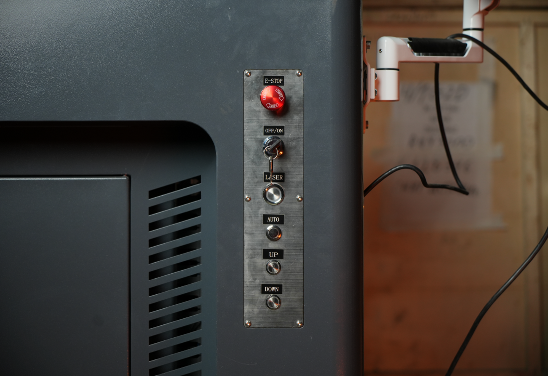 Вертикальная панель управления лазерного станка Wattsan GT с кнопкой E-STOP, ключом зажигания, кнопками Laser, Auto и регуляторами высоты Up/Down.