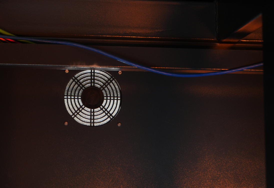 Вытяжной вентилятор с защитной решеткой, установленный в корпусе лазерного станка Wattsan GT для охлаждения компонентов.