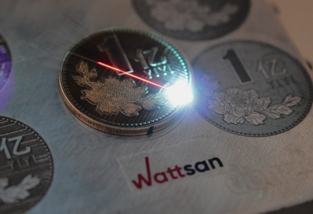 Лазерная маркировка монеты на станке Wattsan: луч обрабатывает поверхность с высокой точностью.