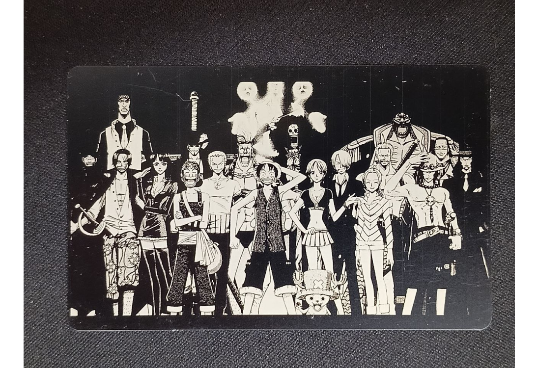 Чёрная карта с гравировкой группы аниме-персонажей из One Piece в белых линиях на тёмном фоне.